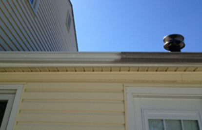 gutter on roof of yellow house